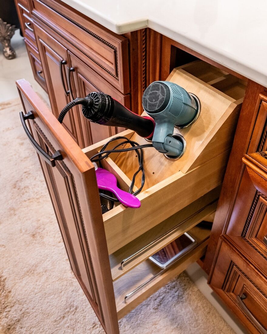 Built-in drawer organizer for hair tools in wooden cabinetry showcasing smart organization hacks for home storage.