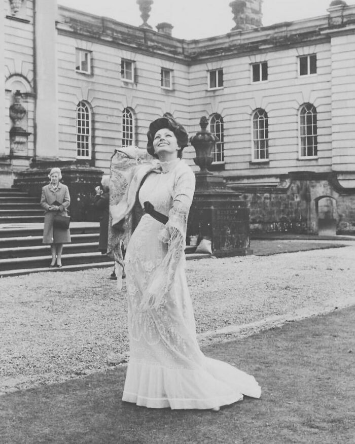 Sophia Loren in an elegant vintage gown posing outdoors in front of a historic building, showcasing classic Italian beauty.
