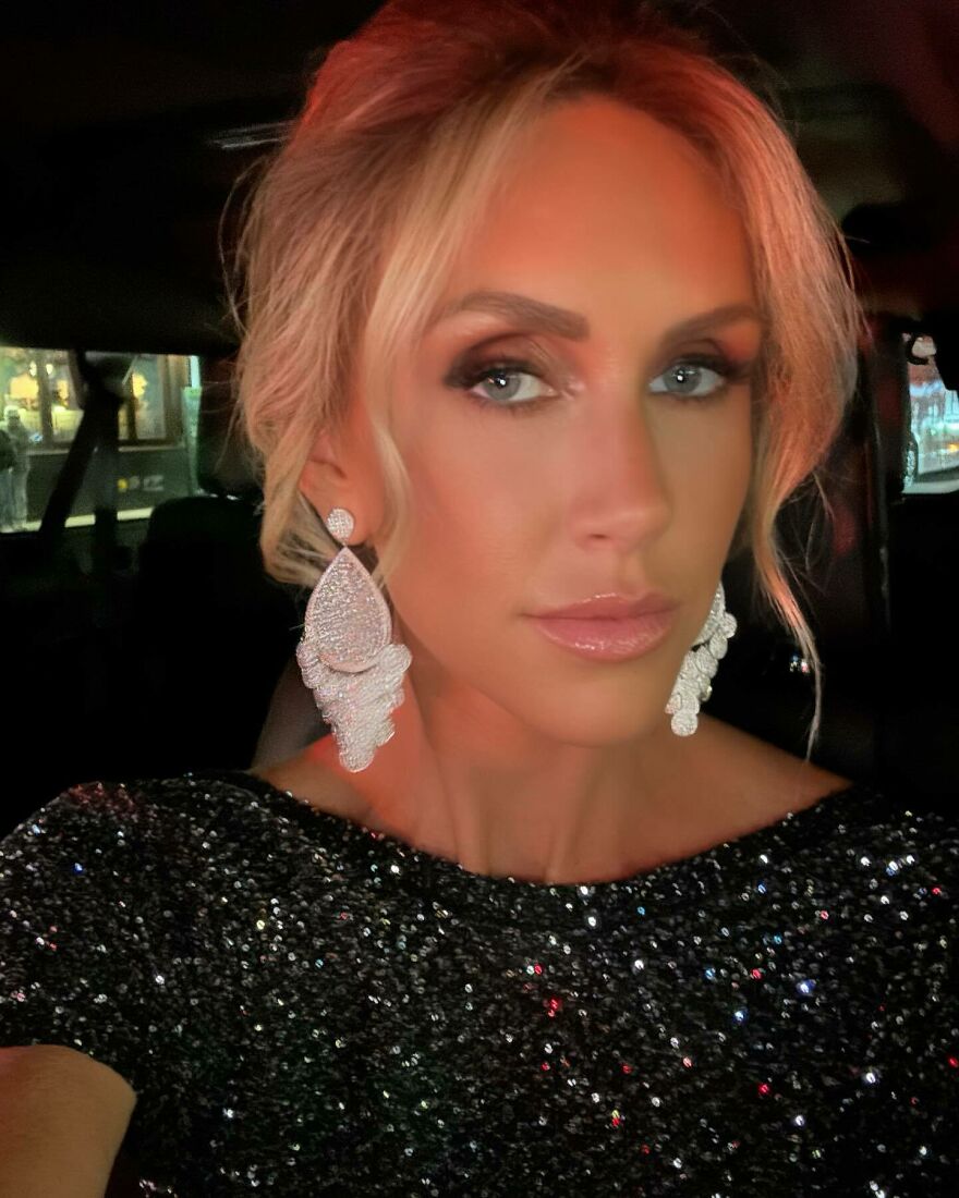 Lara Trump close-up wearing sparkling black dress and large earrings, showcasing glamour in a nighttime setting.
