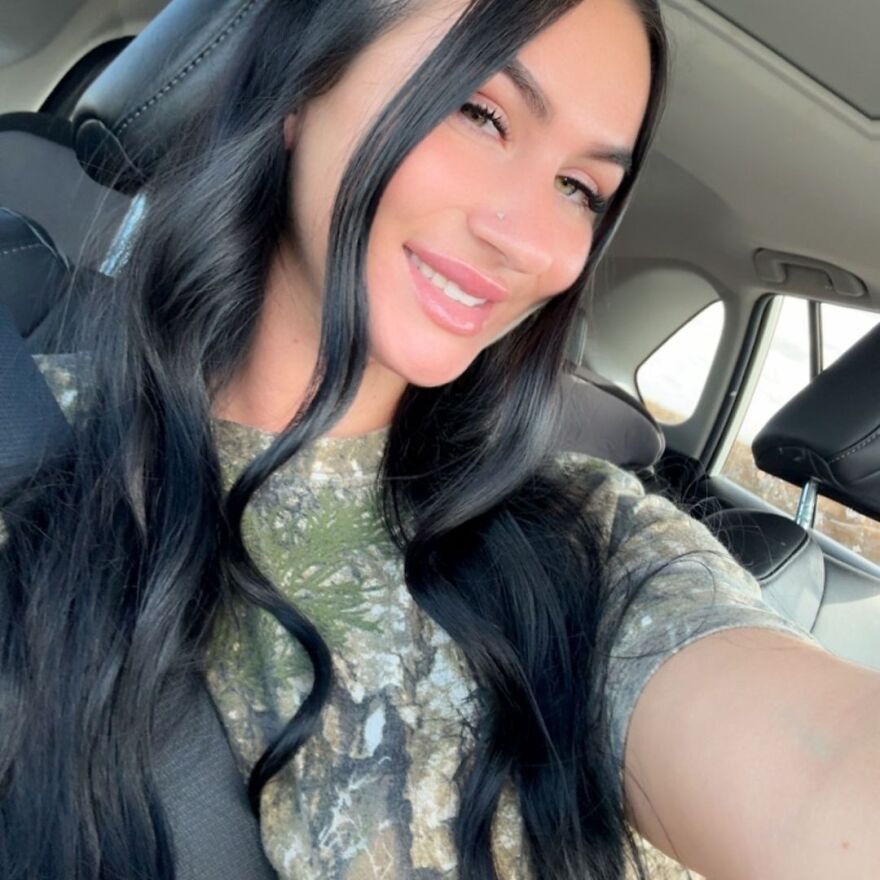 Woman with long black hair smiling inside a car, relating to gender reveal and ex-mother-in-law story.