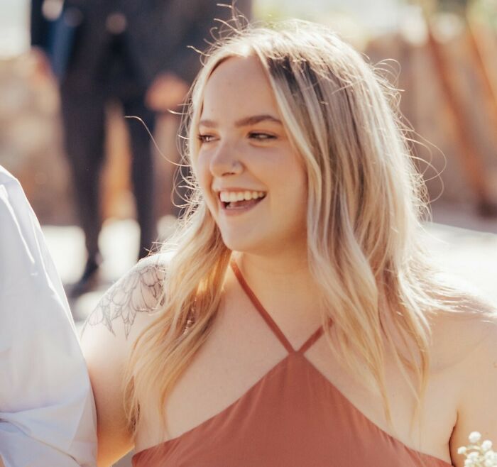 Young woman smiling at a music festival she attended to see Post Malone, capturing a joyful moment.
