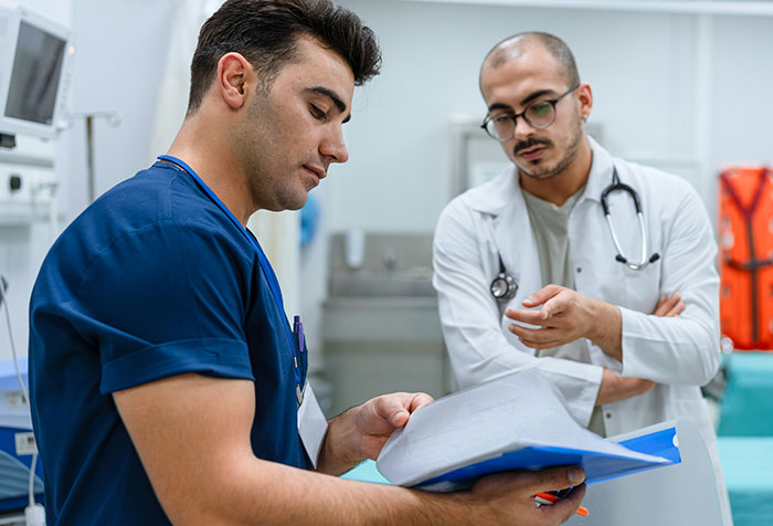 Two medical professionals reviewing documents in a hospital setting illustrating self-diagnosed cases trusted by patients.