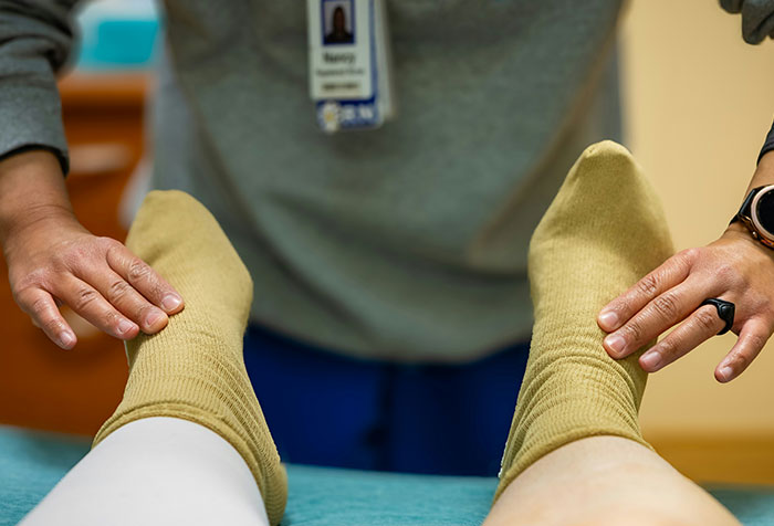 Medical professional examining patient's feet, illustrating cases of self-diagnosed conditions validated despite initial doubt.