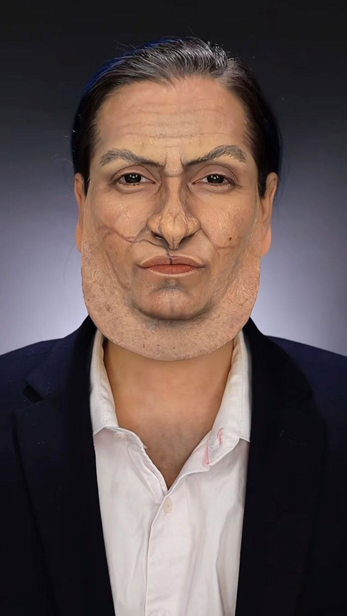 Creative Cliche showcasing amazing Halloween makeup with detailed prosthetics transforming face and neck in a dark blazer and white shirt.