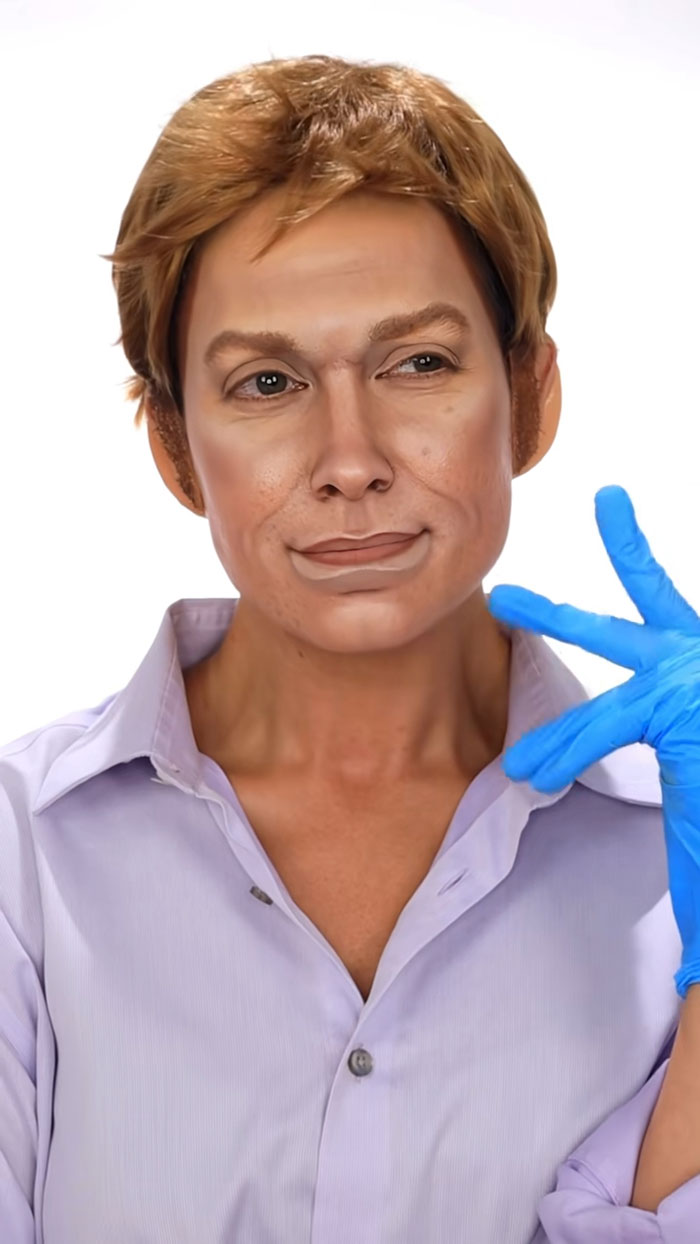 Person wearing creative Halloween makeup with brown hair and wearing blue gloves and a light purple shirt.