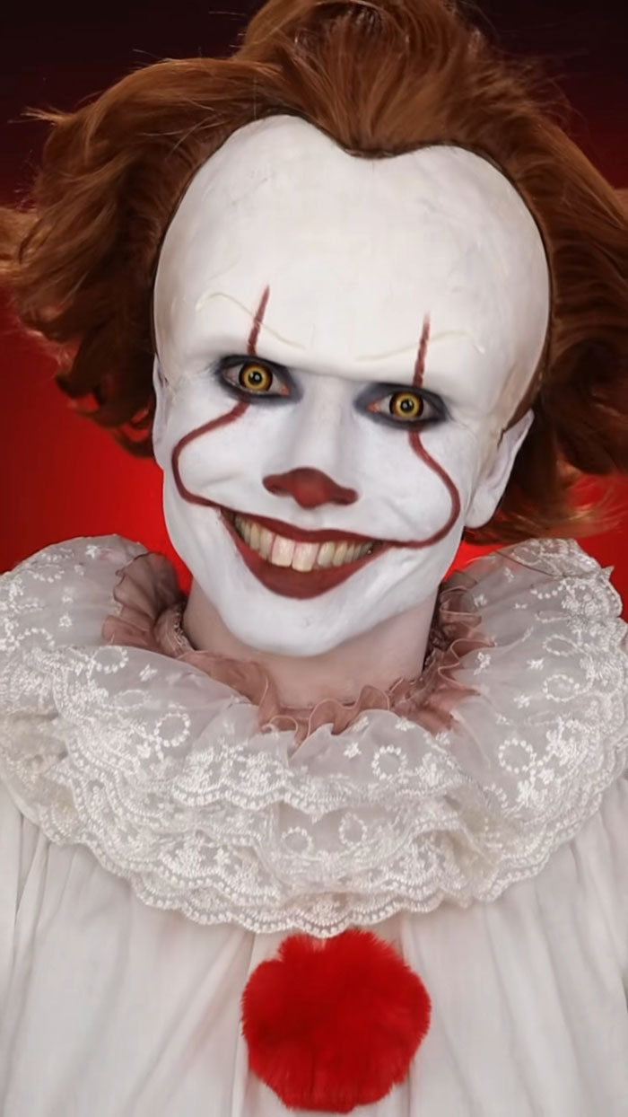 Halloween makeup featuring a detailed creepy clown face with white face paint and red accents by Creator Creative Cliche.