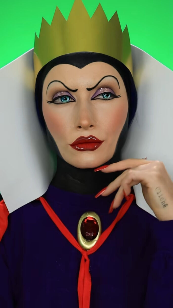 Creative Cliche wearing detailed Halloween makeup as the Evil Queen with a gold crown and dramatic red lips and nails.