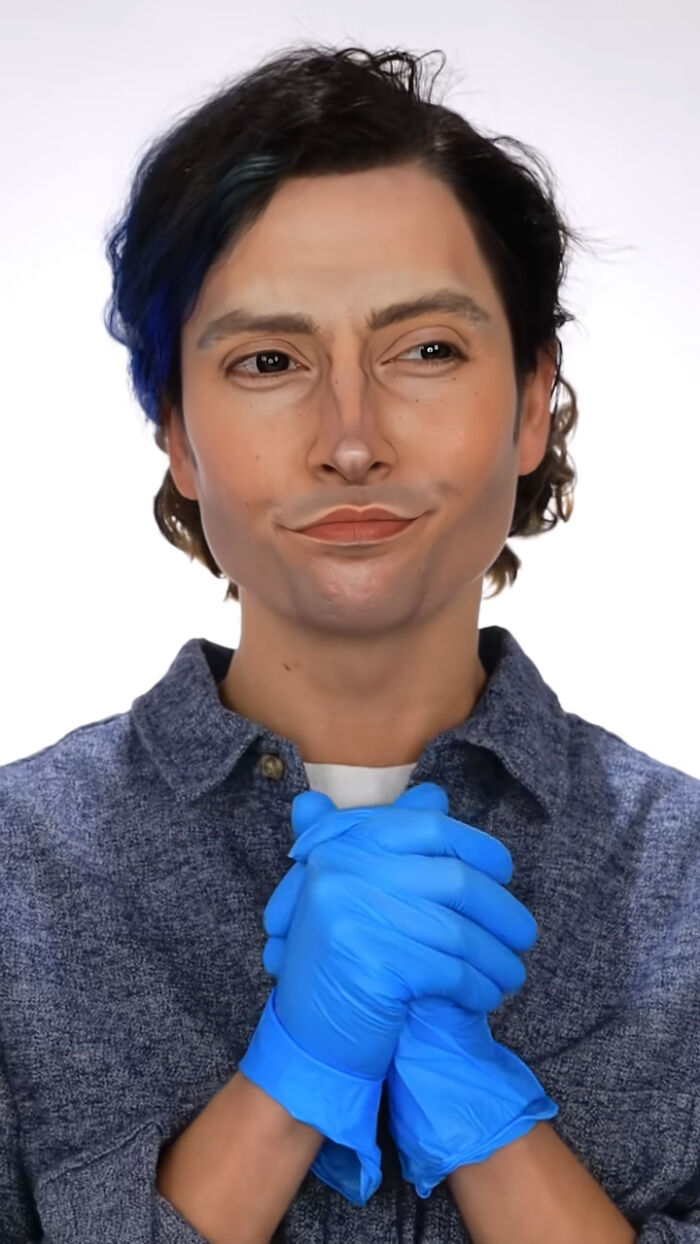 Person wearing detailed Halloween makeup with blue gloves and a blue shirt, showcasing creative Halloween makeup art.