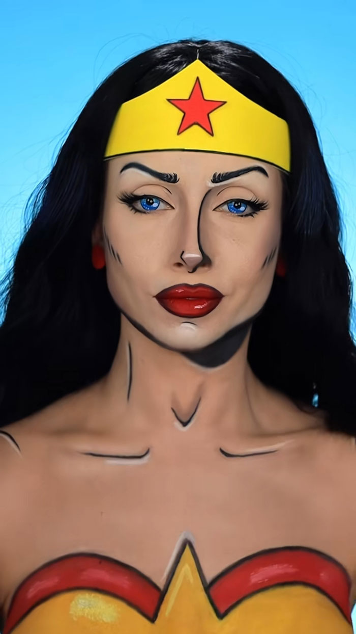 Woman with creative Halloween makeup dressed as comic book Wonder Woman, showcasing amazing body paint and face art.
