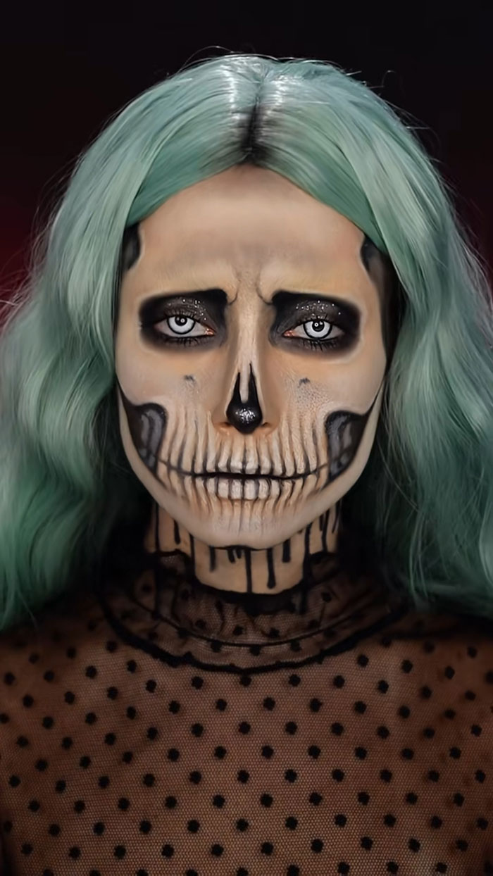 Creative Cliche Halloween makeup with skull face paint and green hair, showcasing amazing spooky makeup artistry and details.