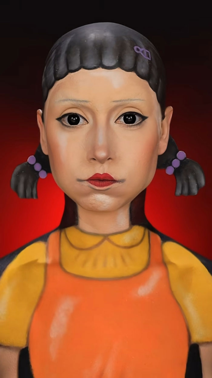 Creative Halloween makeup by Creator Creative Cliche showing detailed face paint resembling a doll with braided hair and pigtails.