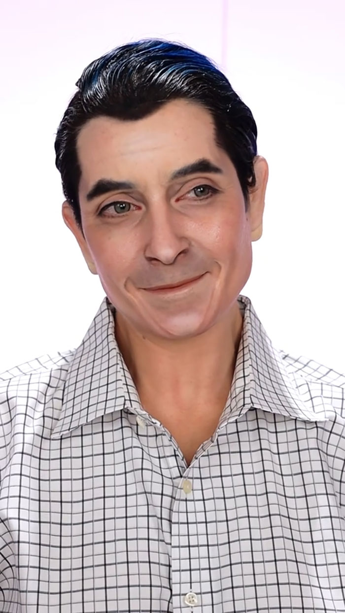 Man with realistic creative Halloween makeup, styled hair, and checkered shirt posing against a white background.