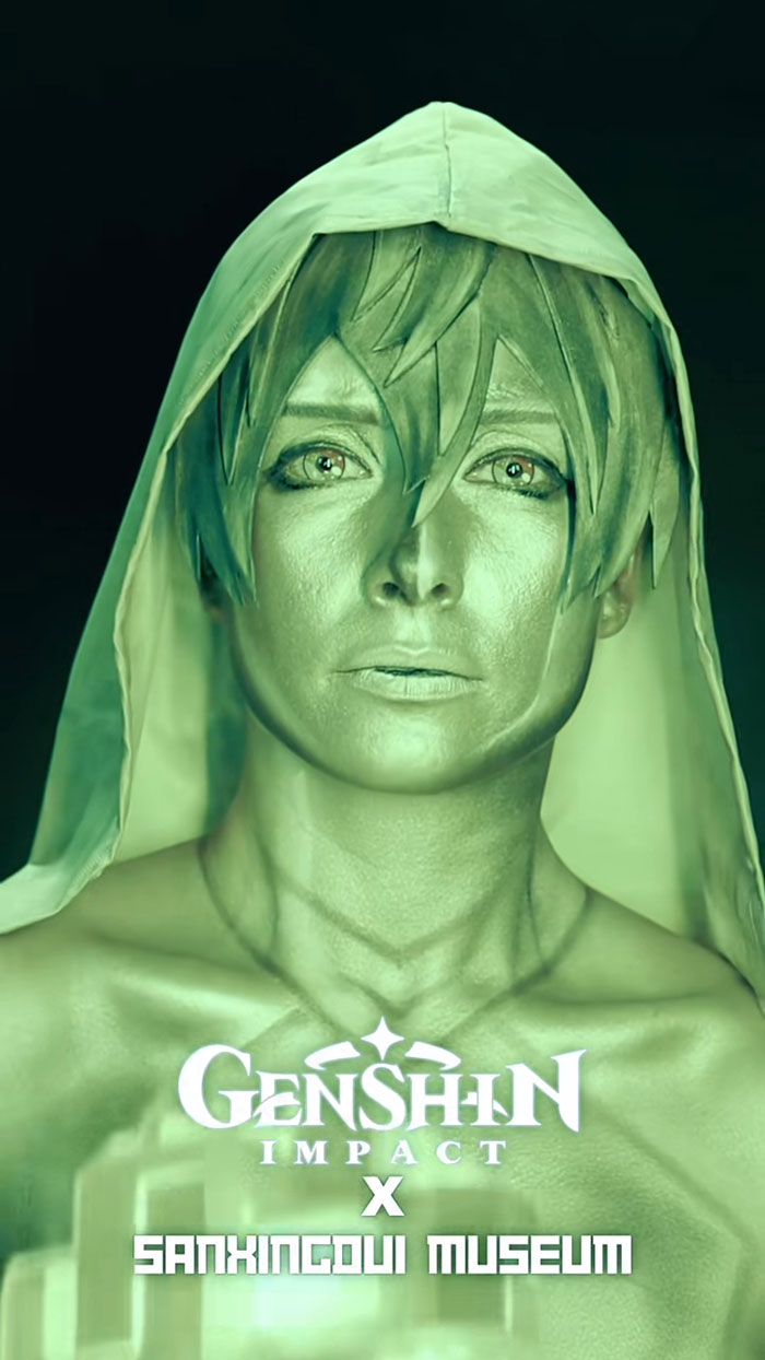 Creative Cliche showcasing amazing Halloween makeup inspired by Genshin Impact character with green metallic face paint and hood.