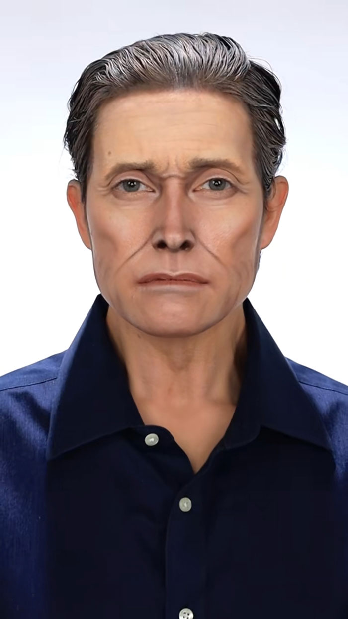 Person with detailed Halloween makeup creating an aged and realistic facial appearance wearing a dark blue shirt.