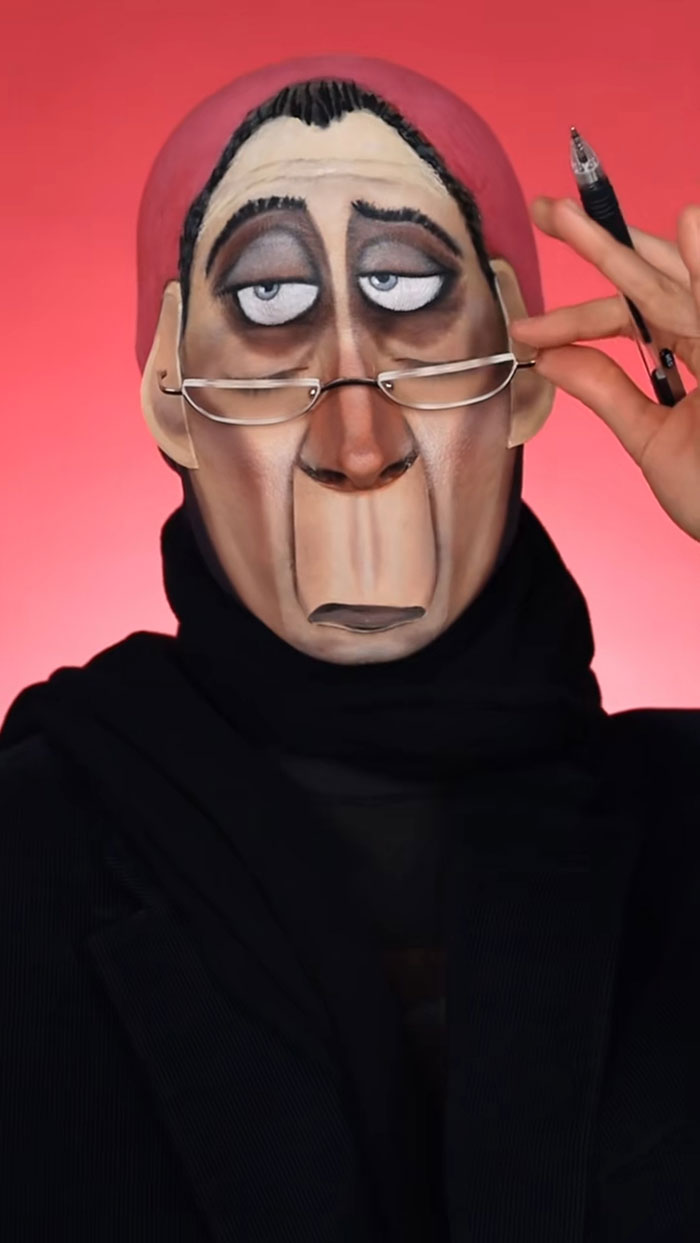 Creative Cliche showcasing amazing Halloween makeup with a cartoonish face design and holding glasses and a pen.