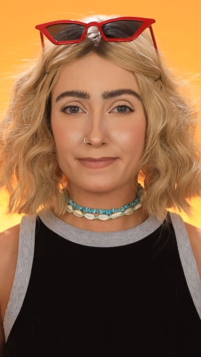 Female creator wearing red sunglasses on head and shell necklace, showcasing creative Halloween makeup ideas and styles.