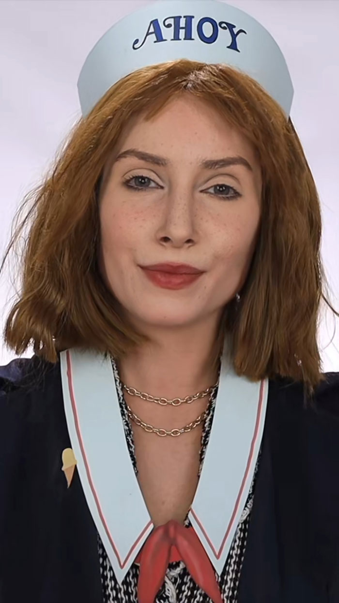 Young woman wearing creative Halloween makeup and a sailor hat with Ahoy text, showcasing artistic Halloween makeup skills.