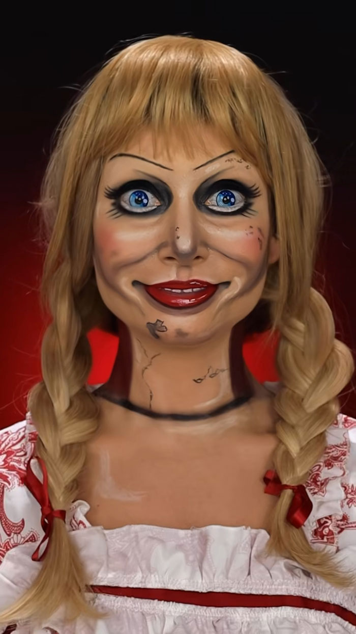 Close-up of Halloween makeup with creepy doll face design featuring detailed shading and bright blue eyes.