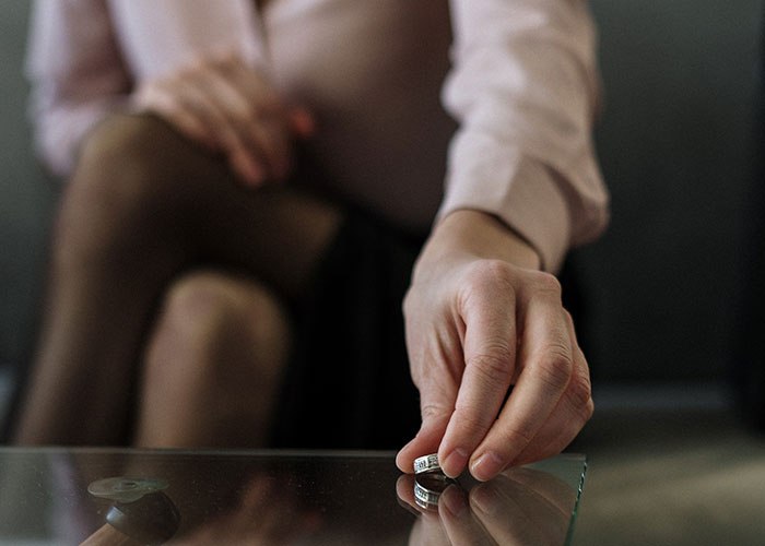 Woman holding a ring, symbolizing relationship struggles as husband refuses to stand up to parents treating wife unfairly.