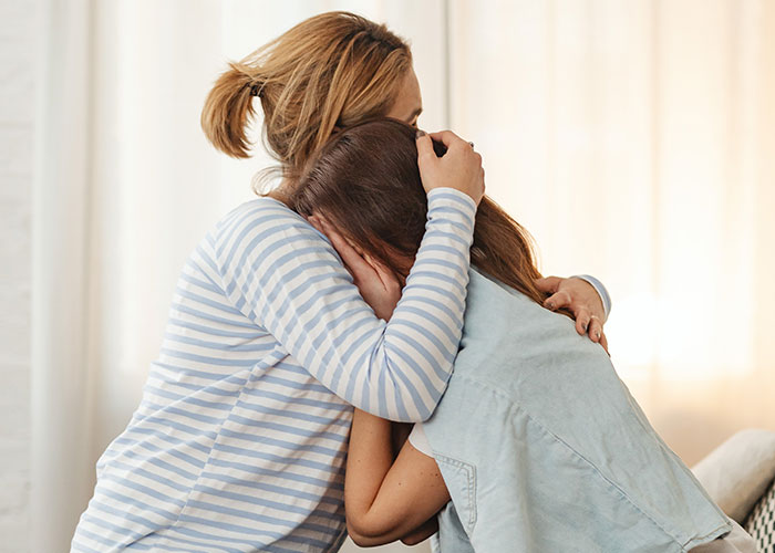 Woman being comforted by another woman, highlighting emotional support amid family and marital struggles.