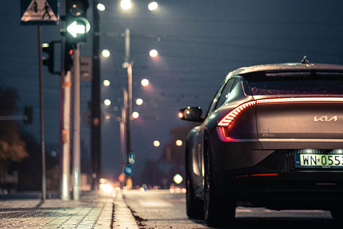 Modern car parked on a dimly lit street at night, illustrating moments of instant karma in everyday life.