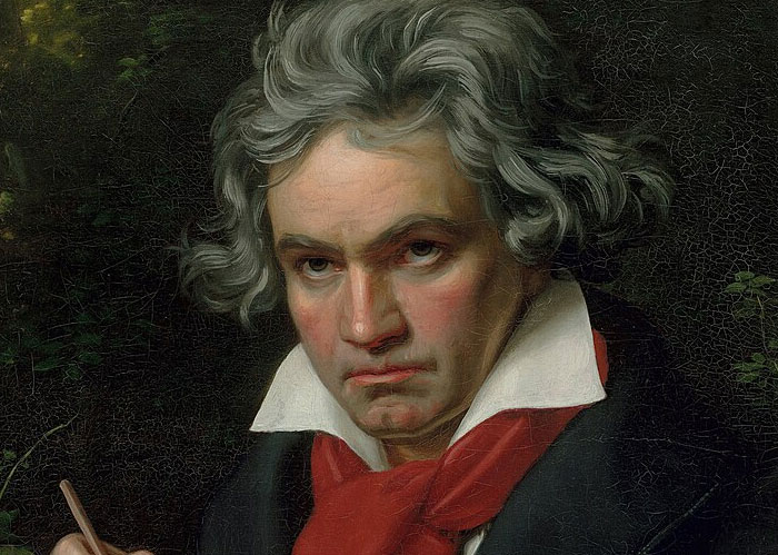 Portrait of a serious man with gray hair, wearing a red scarf and dark coat, illustrating Rihanna slapped him facts.