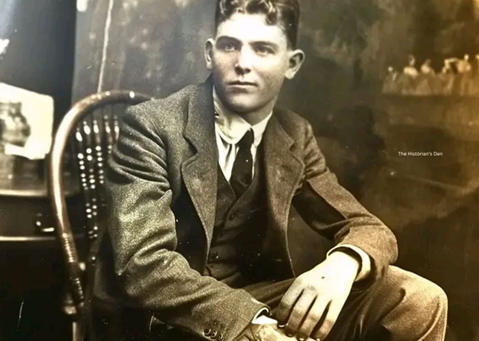 Young man in vintage suit sitting on a wooden chair, black and white photo highlighting fascinating facts and Rihanna slapped him.