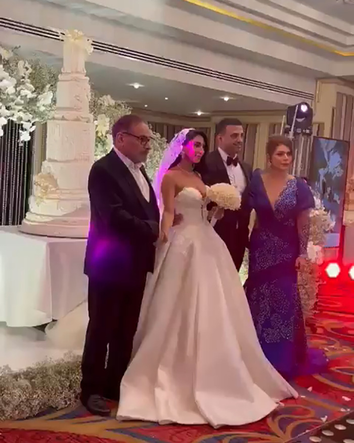 Bride in a risqu&eacute; wedding dress posing with family at an Iranian politician's daughter's wedding amid headscarf surveillance controversy.