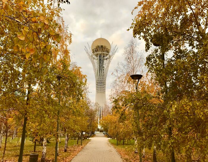 Autumn view of a unique landmark tower surrounded by golden trees, showcasing unbelievable facts about countries.