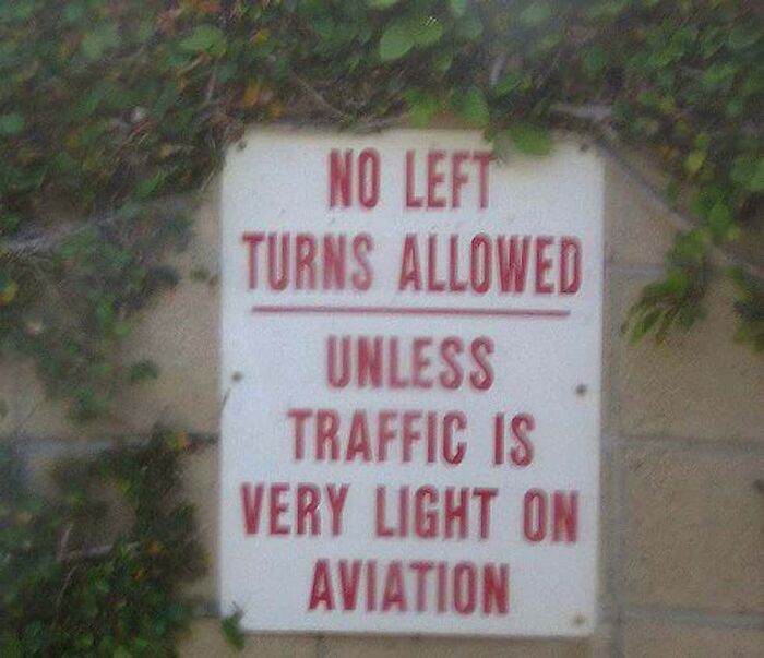 Road sign showing confusing instructions about no left turns unless traffic is very light on aviation.