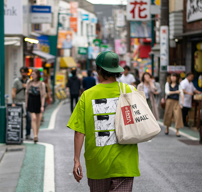 Tourist wearing casual sports attire walking in a busy Japanese street amid a heated restaurant dress code debate. Tourist wearing casual sports attire walking in a busy Japanese street amid a heated restaurant dress code debate.