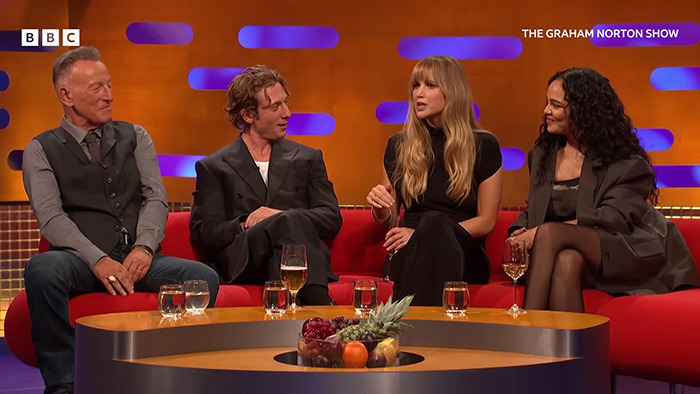 Jennifer Lawrence speaking with other guests on The Graham Norton Show set during a heated response moment.