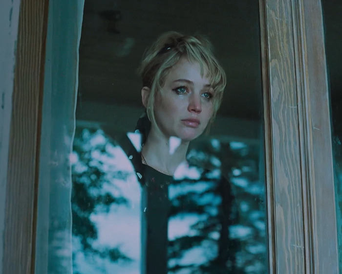 Jennifer Lawrence looking reflective and emotional behind a window, related to her heated response cut from Graham Norton show.