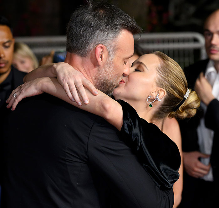 Jennifer Lawrence embracing and kissing a man at a formal event, highlighting rich art dealer relationship topic.