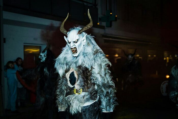 Person wearing a detailed horned monster costume with fur at a night event, illustrating unusual college courses theme.