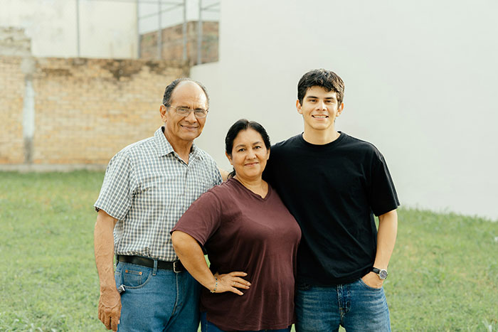 Three family members standing outdoors in a grassy yard, representing a neighbor who found a child and contacted CPS.
