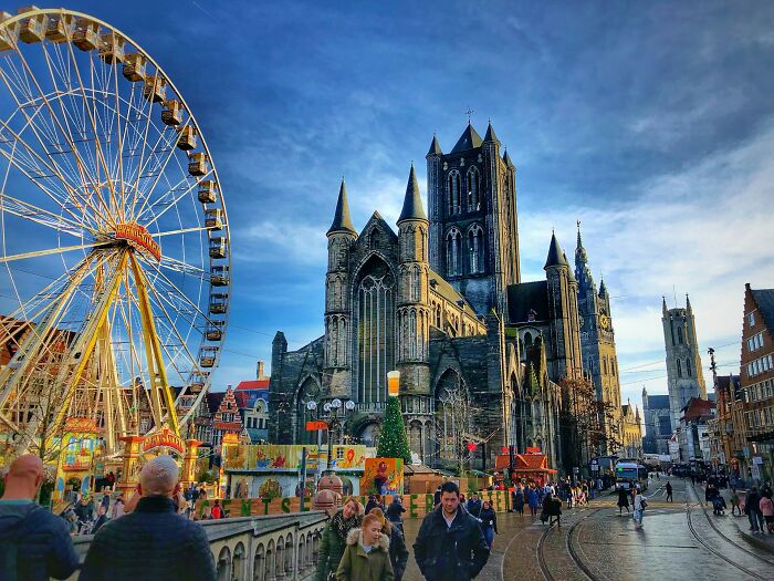 Crowded European street with a historic cathedral and Ferris wheel, showcasing unbelievable facts about countries that are true.
