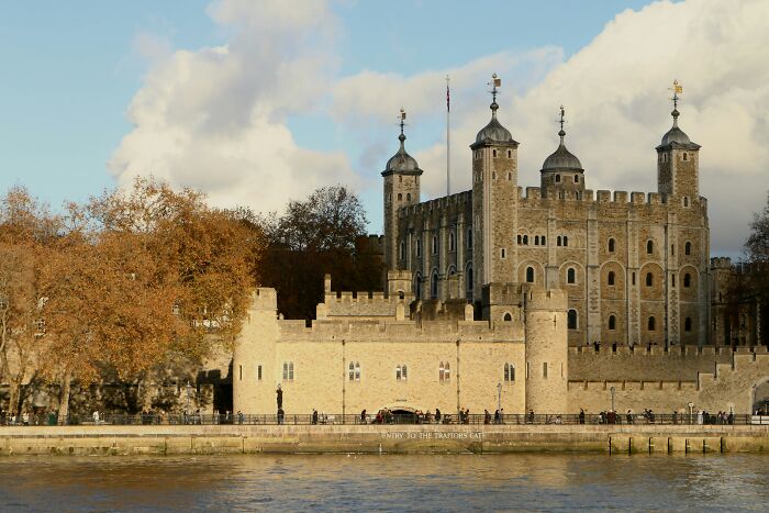 Stone fortress by the river under cloudy sky, a spooky destination known for its haunting history.