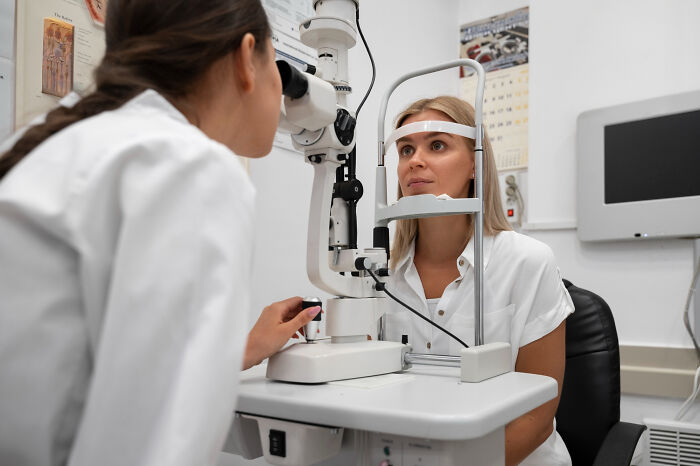 Woman undergoing an eye exam by an optometrist, illustrating how anxiety symptoms can mask actual health issues.