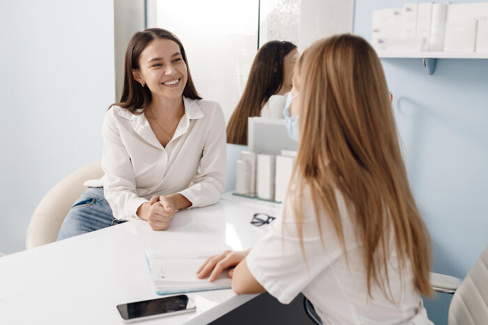 Woman smiling and talking to a healthcare professional during a consultation about anxiety and related health issues