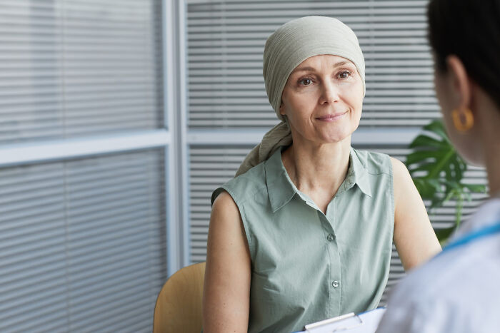 Woman wearing headscarf consulting a doctor in an office, representing people told they were just anxious revealing true issue.