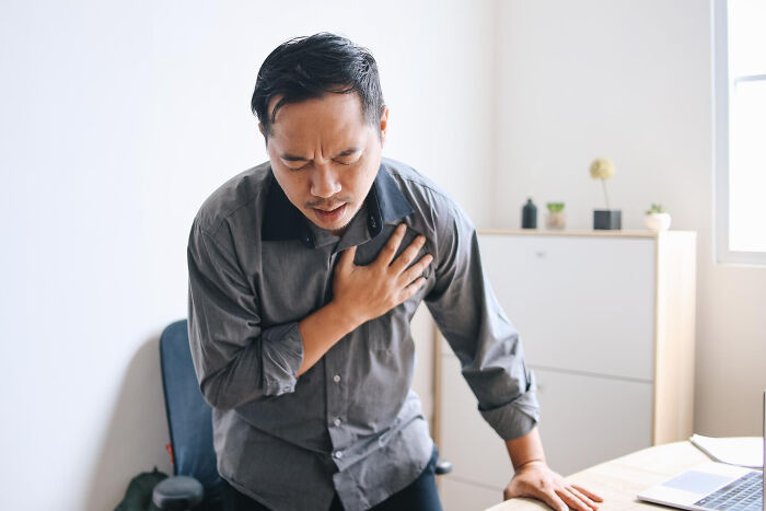 Man clutching chest in pain, illustrating times people were told they were just anxious but had a different issue.
