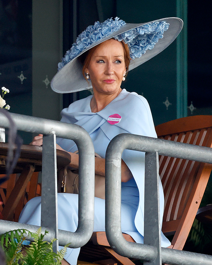 Keira Knightley wearing a blue dress and large flowered hat, seated outdoors amid Harry Potter casting backlash.