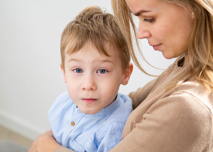 Woman holding her future stepkid, showing emotions of frustration and tiredness over being treated as stranger danger.