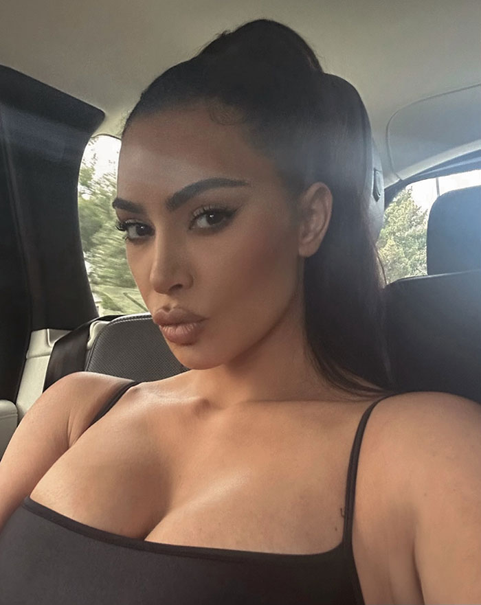 Woman with dark hair in a high ponytail wearing a black tank top, highlighting Kanye West&rsquo;s warning about online life risks.