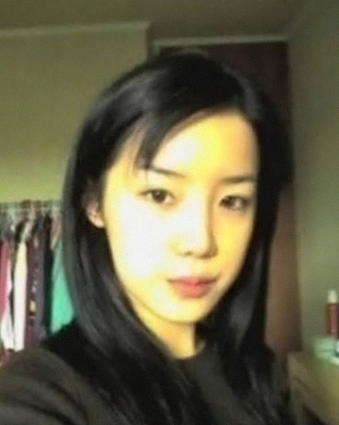 K-Pop icon Park Bom close-up portrait with long black hair indoors, highlighting her plastic surgery transformation.