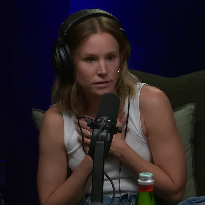 Kristen Bell wearing headphones and speaking into a microphone during a podcast about toxic marriage fights with Dax Shepard.