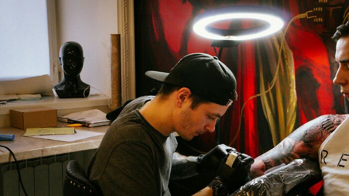 Tattoo artist focused on inking a client's arm in a studio, showcasing moments when tattoo artists messed up.