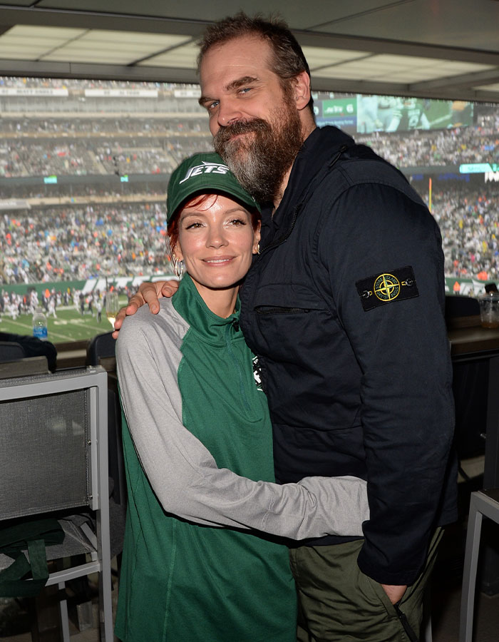 Lily Allen and David Harbour embracing at a crowded sports stadium, linked to explosive album and cheating claims.