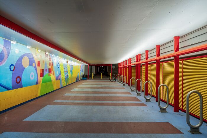 Colorful empty urban tunnel with red accents showcasing a beautiful yet unnerving liminal space perspective.